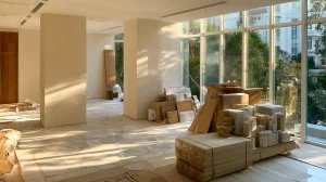 Bright Malaysian living room mid-renovation, exposed walls and fresh flooring, natural light